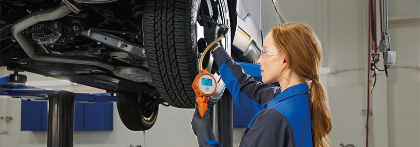 A Subaru technician checking tire pressure. | Jenkins Subaru in Bridgeport WV